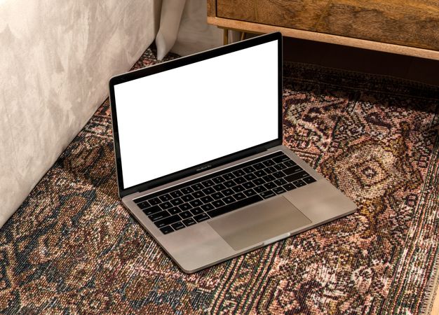 Laptop with blank screen for mockup on rug with pattern