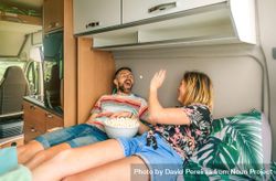 Male and female throwing popcorn at each other on a motorhome bed 5o2z10