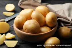 Ceramic bowl full of potatoes on kitchen counter with wedges 4BpwX0