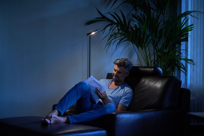 Focused businessman reading papers on leather chair