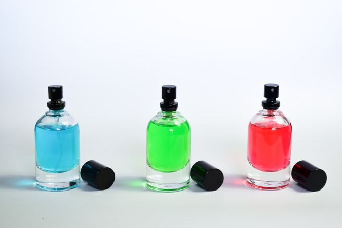Three colorful perfume bottles in a row