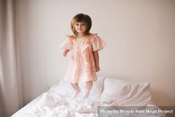 Girl in pink dress jumping on bed 4OJpg5