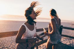 Young women drinking beer at the beach