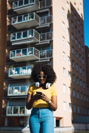 Black woman listening to music with headphones.