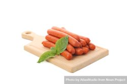Sausage links on wooden board with garnish 49zVLb