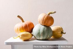 Variety of pumpkins stacked on wooden table 48DpY4