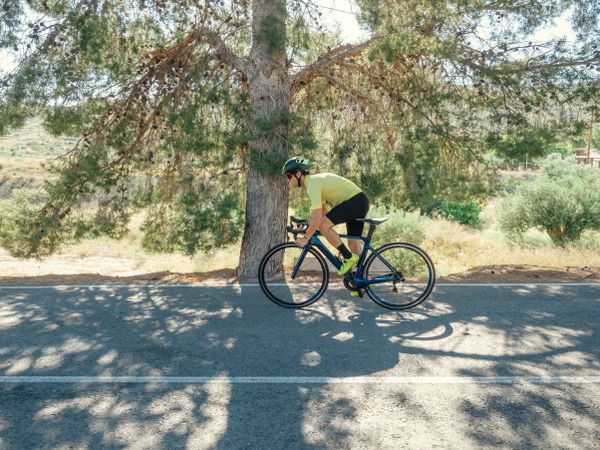healthy man riding a bicycle on a mountain road in a sunny day