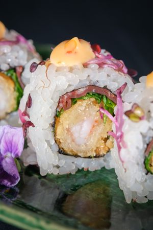 Sushi uramaki served on marble plate in studio
