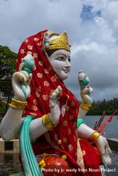 Red veiled Laksmi statue outside by lake 0KZY1b