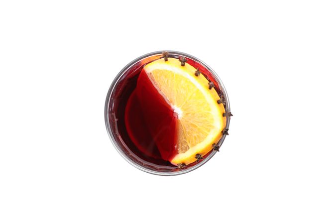 Glass of tasty mulled wine with orange isolated on studio background