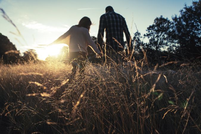 Loving couple walking in golden rural field