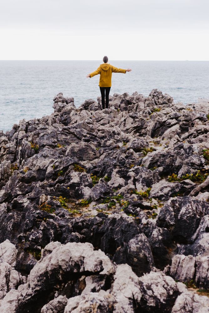 Traveler in solitude walking on rocky shore
