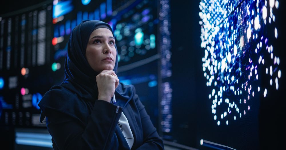 Portrait of a Smart Focused Middle Eastern Software Engineer Analyzing Neural Network Big Data on a Digital Screen.