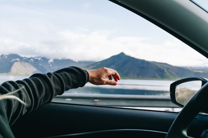 Arm hanging out of car driver’s window