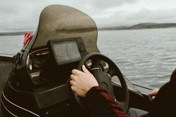 Tourist leading boat on high seas under control of navigator