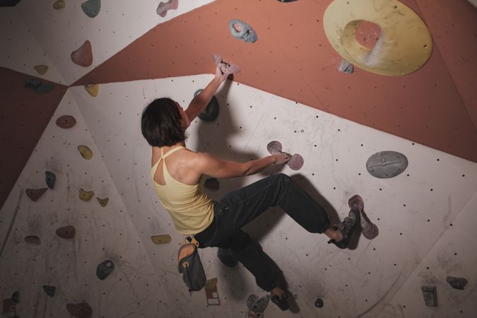 Young woman climbing on wall