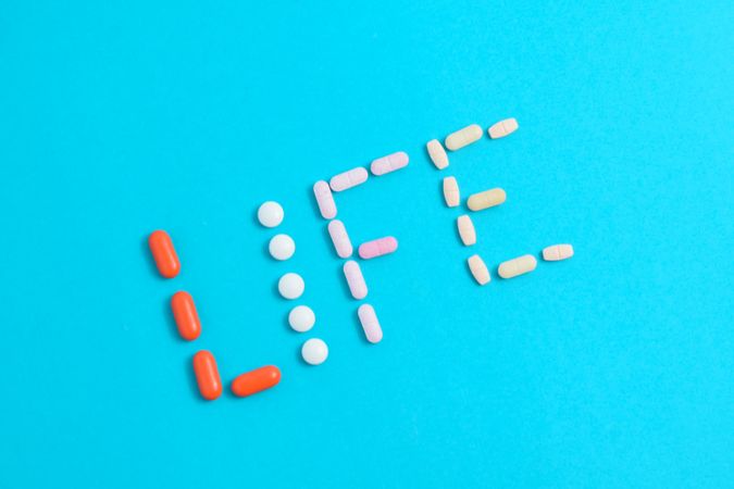 Top view of variety of pills making the word "LIFE" with copy space