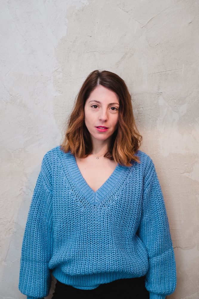 Charming woman in sweater near wall