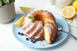Cake with powder sugar and blueberry on blank background, space for text