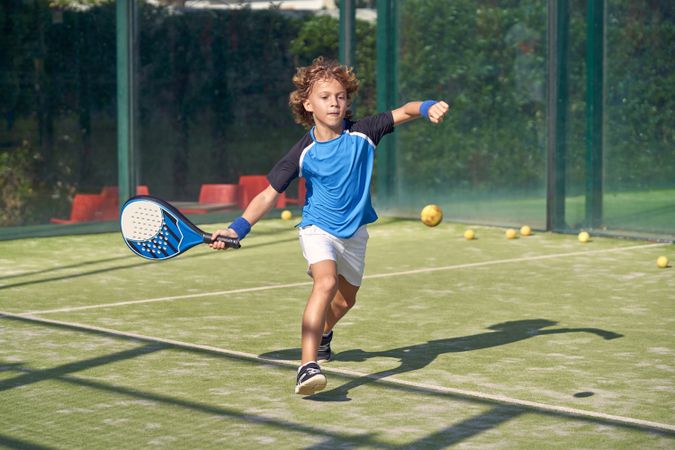 Boy playing padel on court