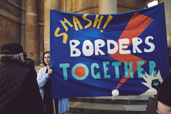 London, England, United Kingdom - March 19 2022: Woman with “Smash Borders Together” sign