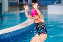 Mother playing with daughter in swimming pool
