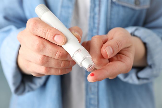 Woman checking blood sugar level, close up