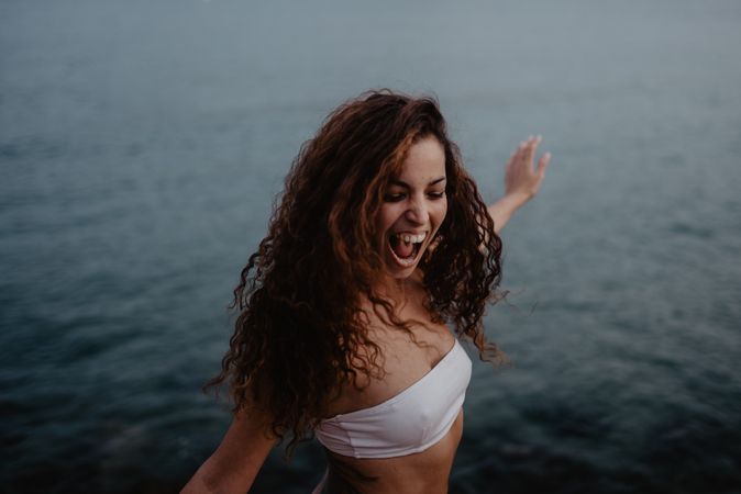 Smiling woman dancing near sea