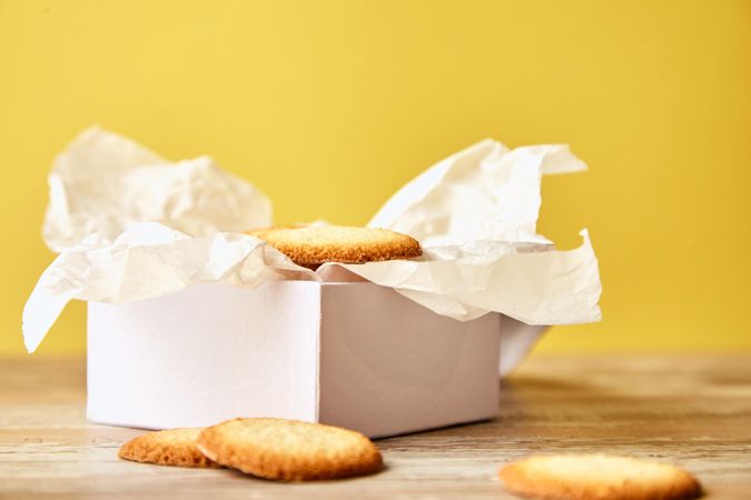 Open box of sugar cookies on yellow background