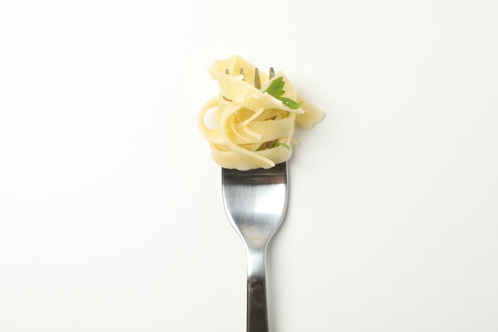 Fork with tasty pasta isolated on blank background