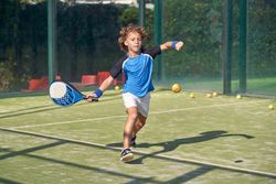 Boy playing padel on court