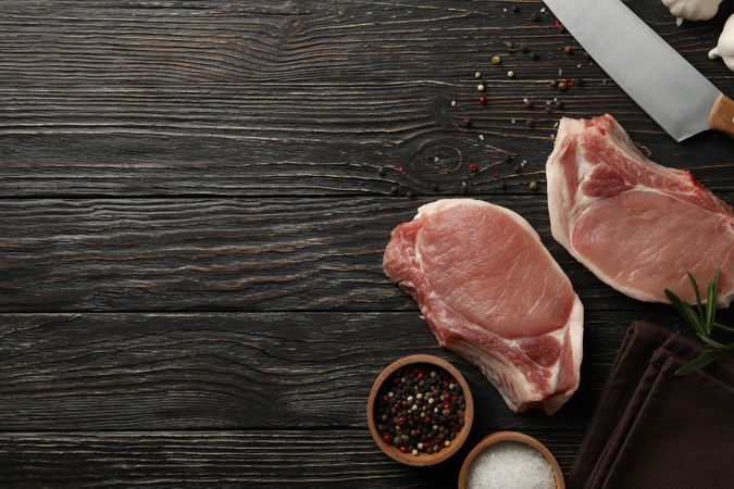 Composition with raw meat for steak and ingredients on wooden background
