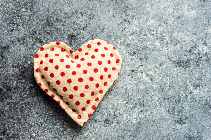 Valentine's day concept with dotted felt heart shaped ornament on grey counter