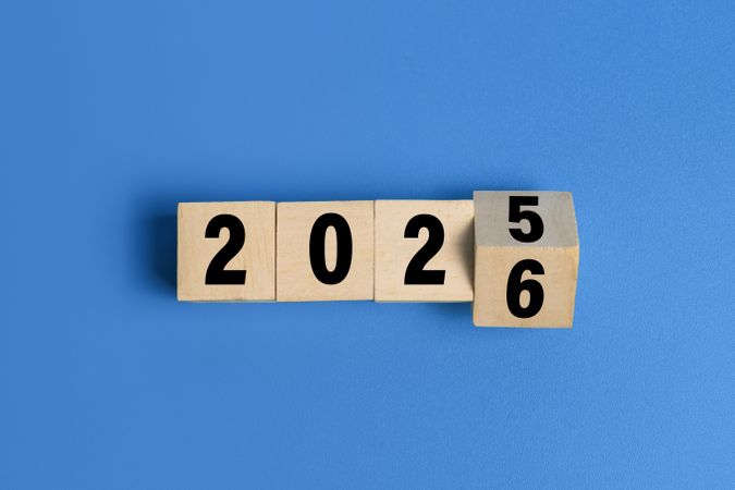 flip wooden blocks with year 2025 to 2026 isolated on blue background
