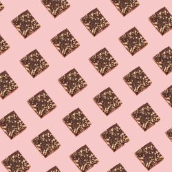 Chocolate square cookie pattern on a soft pink background