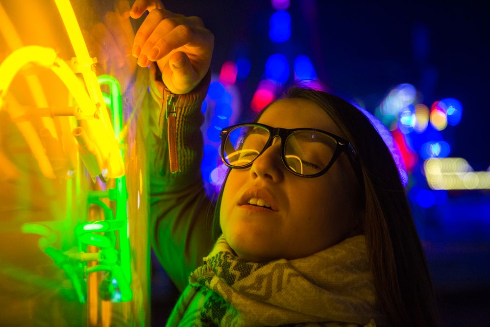 Stylish young woman near illuminated board