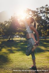 Outdoor shot of fit young woman in sportswear stretching her legs before a run 4Bvpx4
