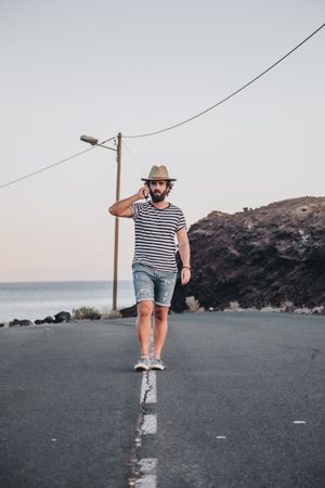 Bearded male in hat on deserted road