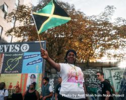 London, England, United Kingdom - August 27, 2022: Woman waving Jamaican flag in London street 5nygQ0