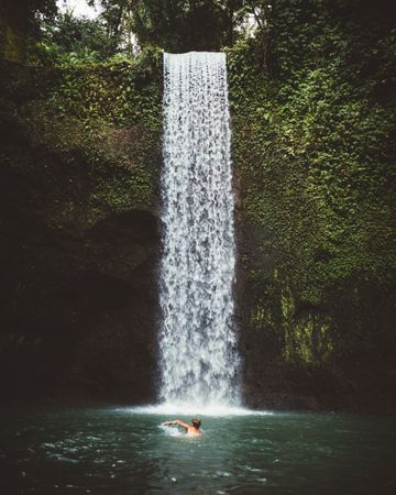 Man swimming in turquoise natural bay