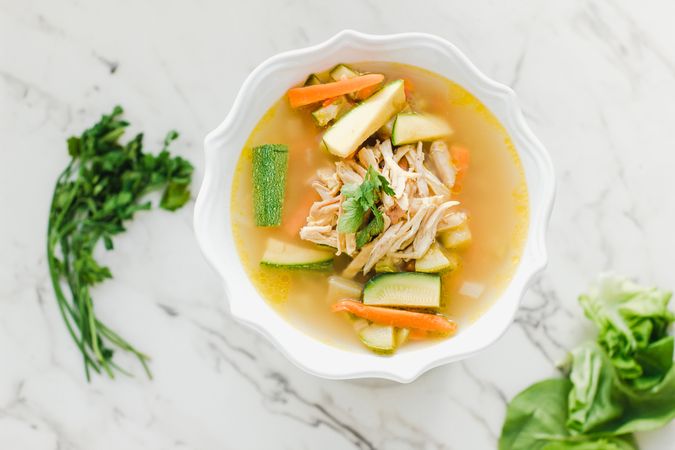 Served chicken soup with carrot and zucchini