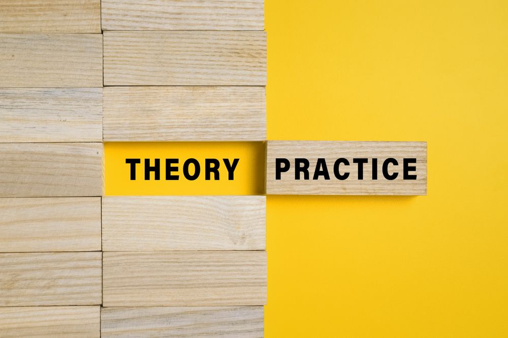 wooden blocks with theory and practice words isolated on yellow background