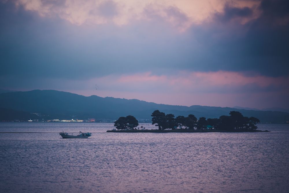Small island with boat at sunset