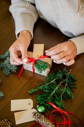 Woman making beautiful Christmas gift at table