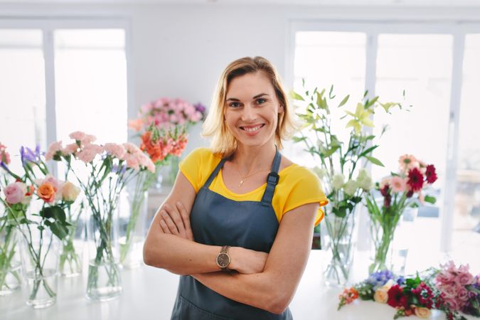 Happy female small business owner standing and smiling in her flower shop