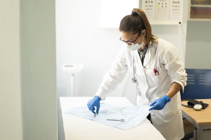 Young doctor with scissors and tweezers on napkin
