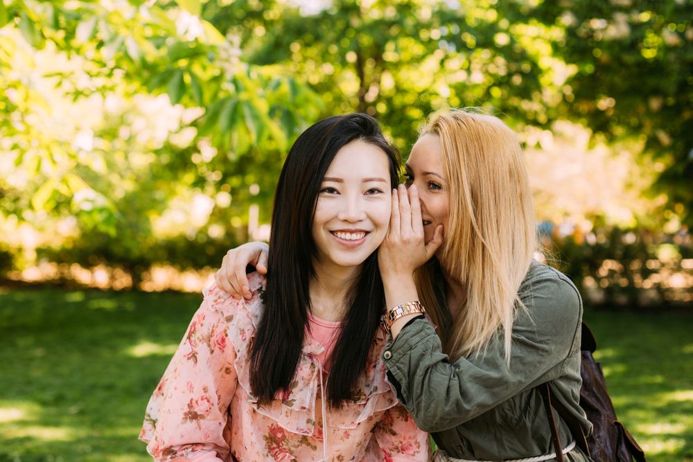 Multiracial female friends gossiping in park