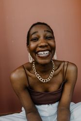 Woman in gold necklace and earrings smiling
