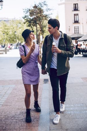 Happy couple walking in the street with ice-creams