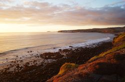 sandy and rocky beach and the ocean in sunset lights in canary island